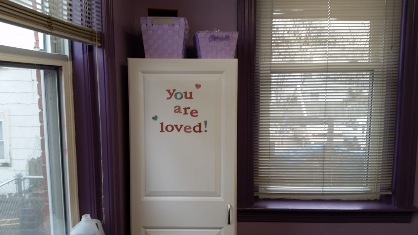 Door displaying a "You Are Loved" sign
