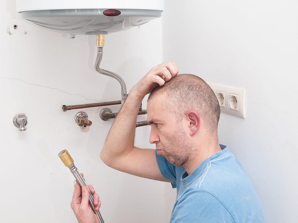 image a of a homeowner scratching his head puzzled by a boiler problem